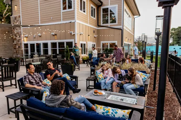 Two guests in rocking chairs look at the drinks menu