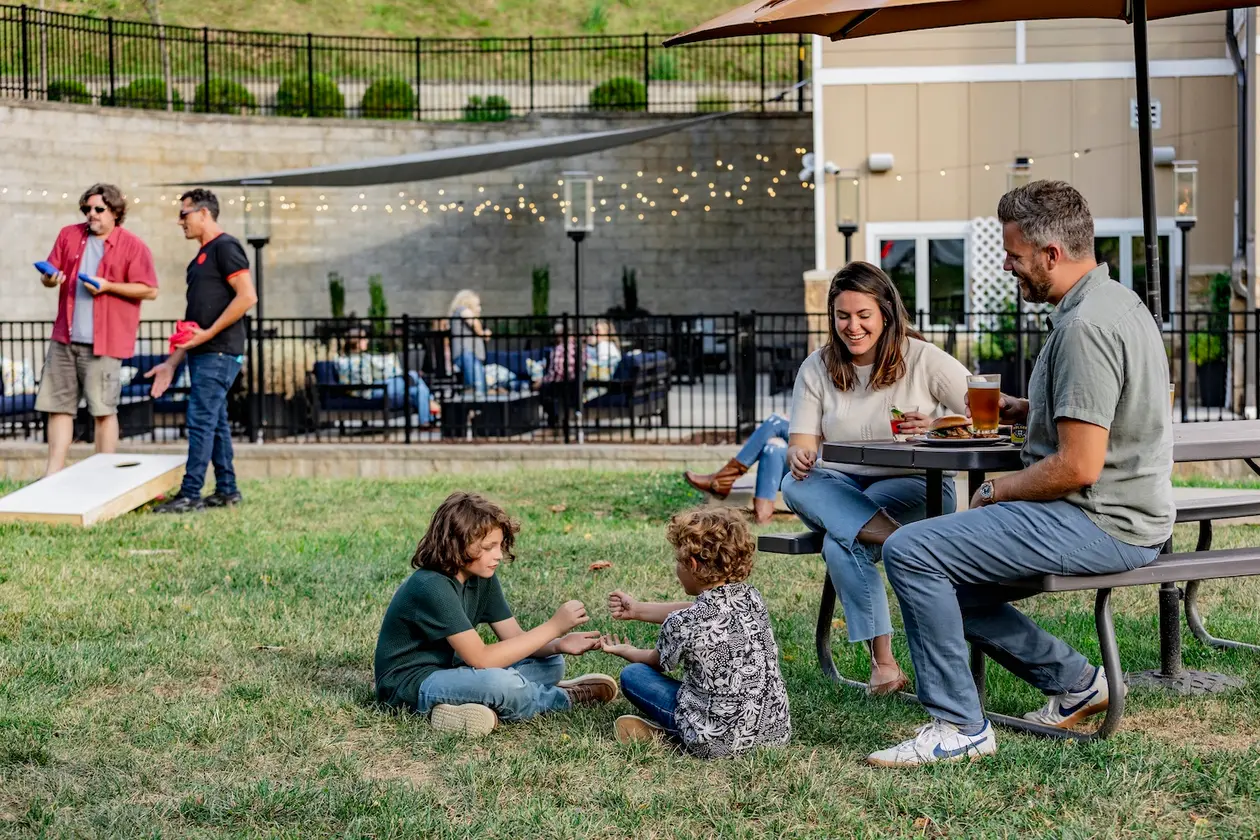 A group of friends relax with drinks and appetizers on the patio before sunset.